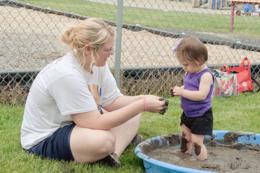 woman playing with child outdoors