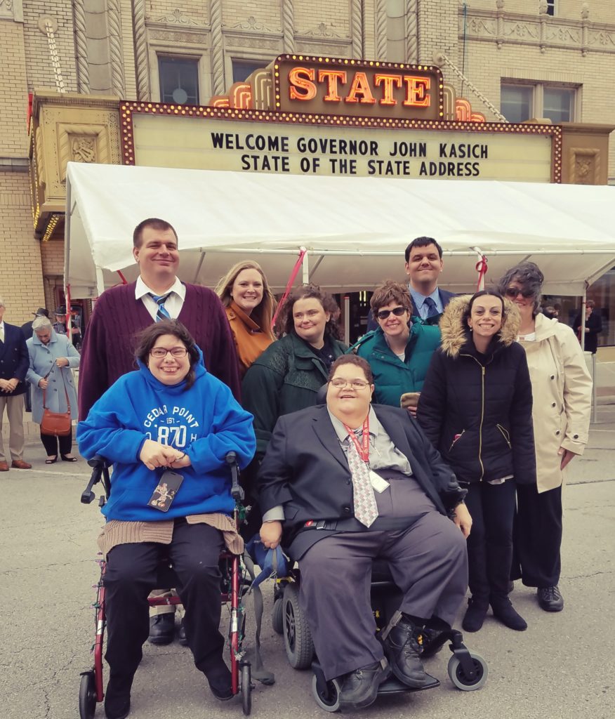 A group of individuals standing outside the sandusky state theater after meeting with the governor