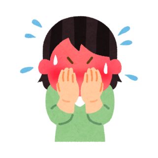 person with dark hair and a green shirt blushing and covering their face