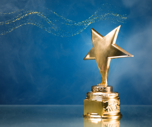 A star shaped trophy against a blue background decorated with glitter